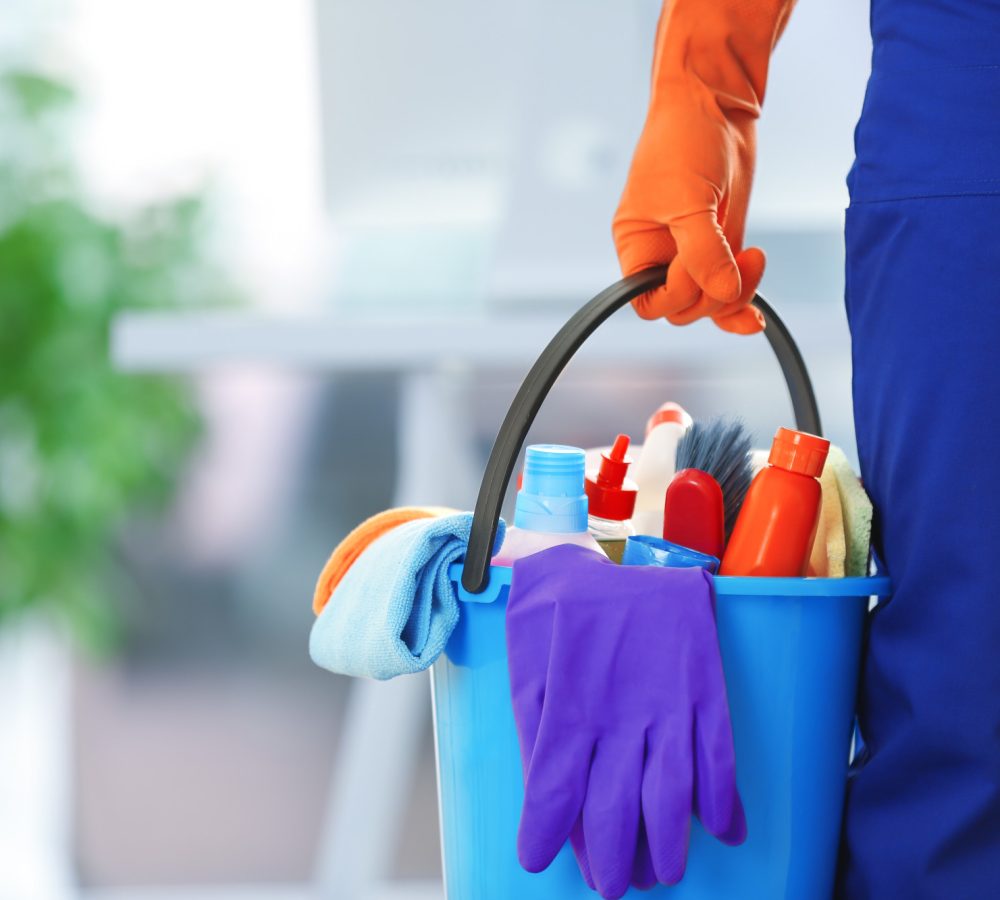 holding cleaning products and tools on bucket, close up
